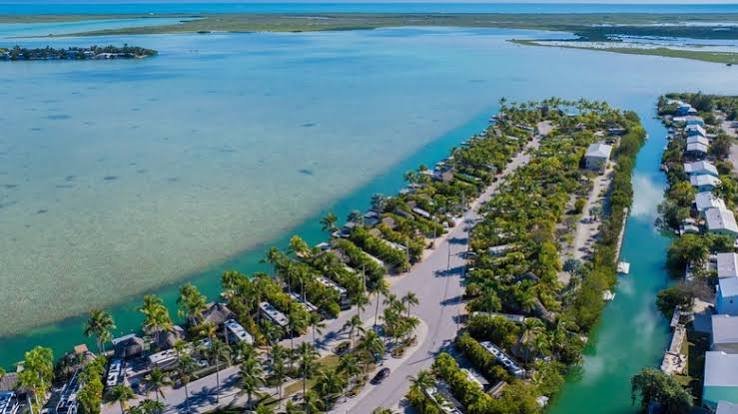 Aerial view of waterfront RV campsites surrounded by palm trees and tropical clear blue water in the Florida Keys. rv park in florida