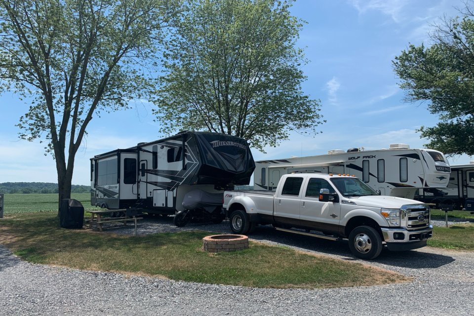 Class A motorhome and pickup truck parked at a full-hookup RV site in Hershey Road Campground near Hershey, PA