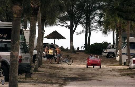 Shaded campsites with picnic tables under palm trees at Turtle Beach Campground in Sarasota, Florida