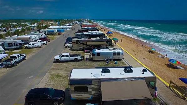 Aerial view of coastal RV resort campsites parked along the water inlet in Florida