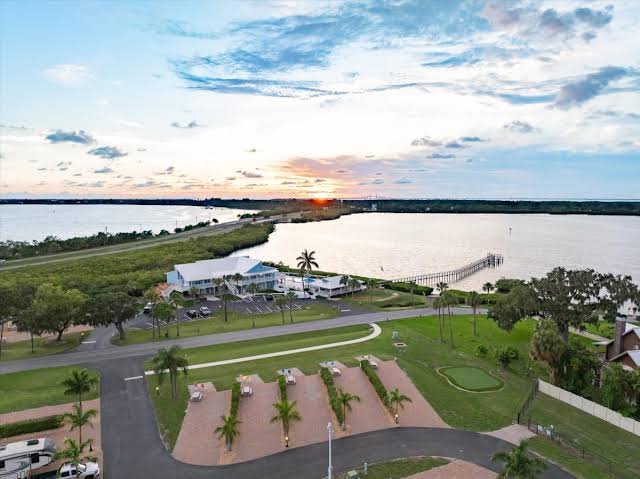 Scenic aerial view of an RV resort setting at sunset with paved roads and waterfront views in Florida